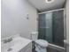 Compact bathroom features a modern glass shower door, toilet and white vanity sink at 6834 Mesa Verde St, Port Richey, FL 34668