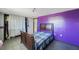 Bedroom featuring a bed, a closet, and purple accent wall at 6834 Mesa Verde St, Port Richey, FL 34668