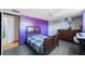 Cozy bedroom featuring a bed, dresser, and a calming purple accent wall at 6834 Mesa Verde St, Port Richey, FL 34668
