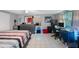 Spacious bedroom features tiled flooring, a dresser, workspaces and a minimalist bed at 6834 Mesa Verde St, Port Richey, FL 34668