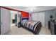 Modern bedroom with striped bedding, tiled flooring and an attached kitchen space at 6834 Mesa Verde St, Port Richey, FL 34668