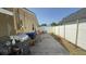 Wide concrete patio area with a barbecue grill and a white privacy fence at 7206 Reindeer Rd, Tampa, FL 33619