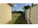 A view of the backyard and side yard showing the fence line and home's siding at 7206 Reindeer Rd, Tampa, FL 33619
