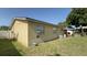Exterior side view of the property, highlighting the block construction and yard at 7206 Reindeer Rd, Tampa, FL 33619