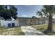 Front view of the house featuring well-maintained landscaping, a concrete driveway, and a cozy front porch area at 7206 Reindeer Rd, Tampa, FL 33619