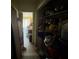 Hallway leading to a bright room, with a closet full of various items at 7206 Reindeer Rd, Tampa, FL 33619
