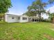 Exterior view of a white house with a covered patio and a spacious backyard at 7571 Ridge Rd, Seminole, FL 33772