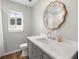 Updated bathroom featuring a modern vanity with decorative mirror and wood-look flooring at 7571 Ridge Rd, Seminole, FL 33772