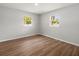 Bright bedroom with wood-look flooring and two windows offering natural light at 7571 Ridge Rd, Seminole, FL 33772