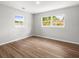 Well-lit bedroom with two windows offering natural light and wood-look flooring at 7571 Ridge Rd, Seminole, FL 33772