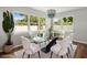 Bright dining area featuring a modern glass table, white chairs, and a stylish chandelier at 7571 Ridge Rd, Seminole, FL 33772