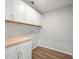 Bright laundry room featuring white cabinets, wood countertop, and wood-look flooring at 7571 Ridge Rd, Seminole, FL 33772