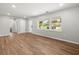 Well-lit living room featuring hardwood floors, neutral paint, a doorway, and large windows with an outside view at 7571 Ridge Rd, Seminole, FL 33772