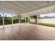Covered patio with wood-look flooring, bright ceiling and view of landscaped backyard at 7571 Ridge Rd, Seminole, FL 33772