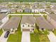 Aerial view of home with well-manicured lawn and landscaping in a community with white fence at 81 Rain Lily Ave, Spring Hill, FL 34609