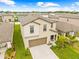 Two-story home with well-maintained landscaping and a long driveway, viewed aerially at 81 Rain Lily Ave, Spring Hill, FL 34609