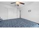 Bedroom features a ceiling fan, closet, and bed, with carpet flooring and neutral paint at 81 Rain Lily Ave, Spring Hill, FL 34609