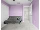 Cozy bedroom features soft gray carpeting, a comfortable futon, and a calming lavender color scheme at 81 Rain Lily Ave, Spring Hill, FL 34609