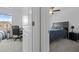 Hallway view into two bedrooms, one with desk and the other with a queen bed and nightstand at 81 Rain Lily Ave, Spring Hill, FL 34609