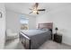 Bedroom features a ceiling fan, bed with dark wood frame, nightstand, and a fuzzy accent chair at 81 Rain Lily Ave, Spring Hill, FL 34609