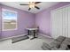Bedroom with lilac paint features a ceiling fan, closet, desk, and workout equipment on carpet at 81 Rain Lily Ave, Spring Hill, FL 34609