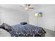 Well-lit bedroom with a floral patterned bedspread and a wall-mounted television at 81 Rain Lily Ave, Spring Hill, FL 34609