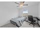 Bright bedroom features a ceiling fan, a bed, and a desk with a chair next to the window at 81 Rain Lily Ave, Spring Hill, FL 34609