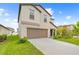 Attractive two-story home featuring a two-car garage, green lawn, and beautifully landscaped front yard at 81 Rain Lily Ave, Spring Hill, FL 34609