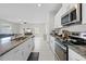 Modern kitchen features granite countertops and stainless steel appliances, with an open floor plan at 81 Rain Lily Ave, Spring Hill, FL 34609