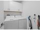 Bright laundry room with washer, dryer and white cabinets for storage at 81 Rain Lily Ave, Spring Hill, FL 34609
