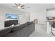 Open-concept living room with tile flooring and a cozy gray sectional sofa at 81 Rain Lily Ave, Spring Hill, FL 34609