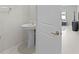 Modern powder room featuring a pedestal sink with gold fixtures and white walls at 81 Rain Lily Ave, Spring Hill, FL 34609