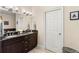 Bathroom featuring double sinks with granite countertop and dark wood cabinets, with a white door at 829 Date Palm Ln, St Petersburg, FL 33707