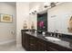 Bright bathroom featuring double sinks with granite countertops, and a mirror with modern lighting at 829 Date Palm Ln, St Petersburg, FL 33707