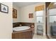 Bright bathroom with a white soaking tub, window, tiled walls, and modern fixtures at 829 Date Palm Ln, St Petersburg, FL 33707