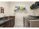 Laundry room with sink, granite countertops, modern appliances and tile flooring at 829 Date Palm Ln, St Petersburg, FL 33707