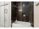 Modern shower and tub combination with glass door, mosaic tile accents, and niche for storage at 829 Date Palm Ln, St Petersburg, FL 33707