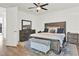 This primary bedroom features a ceiling fan, a wood-look bed, and a dresser with a rectangular mirror at 8714 Palm Ranches Pl, Tampa, FL 33614