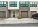 Close-up view of a contemporary townhome exterior with an attached garage, tidy landscaping, and modern accents at 8714 Palm Ranches Pl, Tampa, FL 33614
