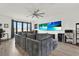 This large living room features a giant couch, hardwood floors, a ceiling fan, and a flatscreen TV at 8714 Palm Ranches Pl, Tampa, FL 33614
