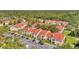 Aerial view of a residential complex with red roofs, lush greenery, and ample parking in a desirable location at 9481 Highland Oak Dr # 806, Tampa, FL 33647