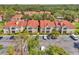 Aerial view of condo community with red tile roofs surrounded by lush greenery and parking at 9481 Highland Oak Dr # 806, Tampa, FL 33647