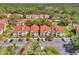 Aerial view of condo community with lush landscaping, red tile roofs and ample parking at 9481 Highland Oak Dr # 806, Tampa, FL 33647