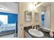 Bathroom with a single sink vanity, granite counters, a large mirror, and a view into the bedroom at 9481 Highland Oak Dr # 806, Tampa, FL 33647