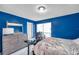 This bedroom is equipped with a bed, desk, and dresser, and has blue walls and tile floors at 9481 Highland Oak Dr # 806, Tampa, FL 33647
