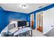 Bedroom with bright blue walls, a desk with computer equipment, tile floors and a bathroom view at 9481 Highland Oak Dr # 806, Tampa, FL 33647