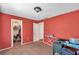 Bedroom featuring red walls, a patterned armchair, and an ironing board with a closet at 9481 Highland Oak Dr # 806, Tampa, FL 33647