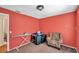 Bedroom featuring red walls, a patterned armchair, and an ironing board at 9481 Highland Oak Dr # 806, Tampa, FL 33647