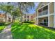 Condo building featuring screened patios surrounded by lush lawns and mature trees at 9481 Highland Oak Dr # 806, Tampa, FL 33647