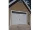 Single-car garage with a white door that matches the neutral exterior paint, and well-maintained landscaping at 9481 Highland Oak Dr # 806, Tampa, FL 33647